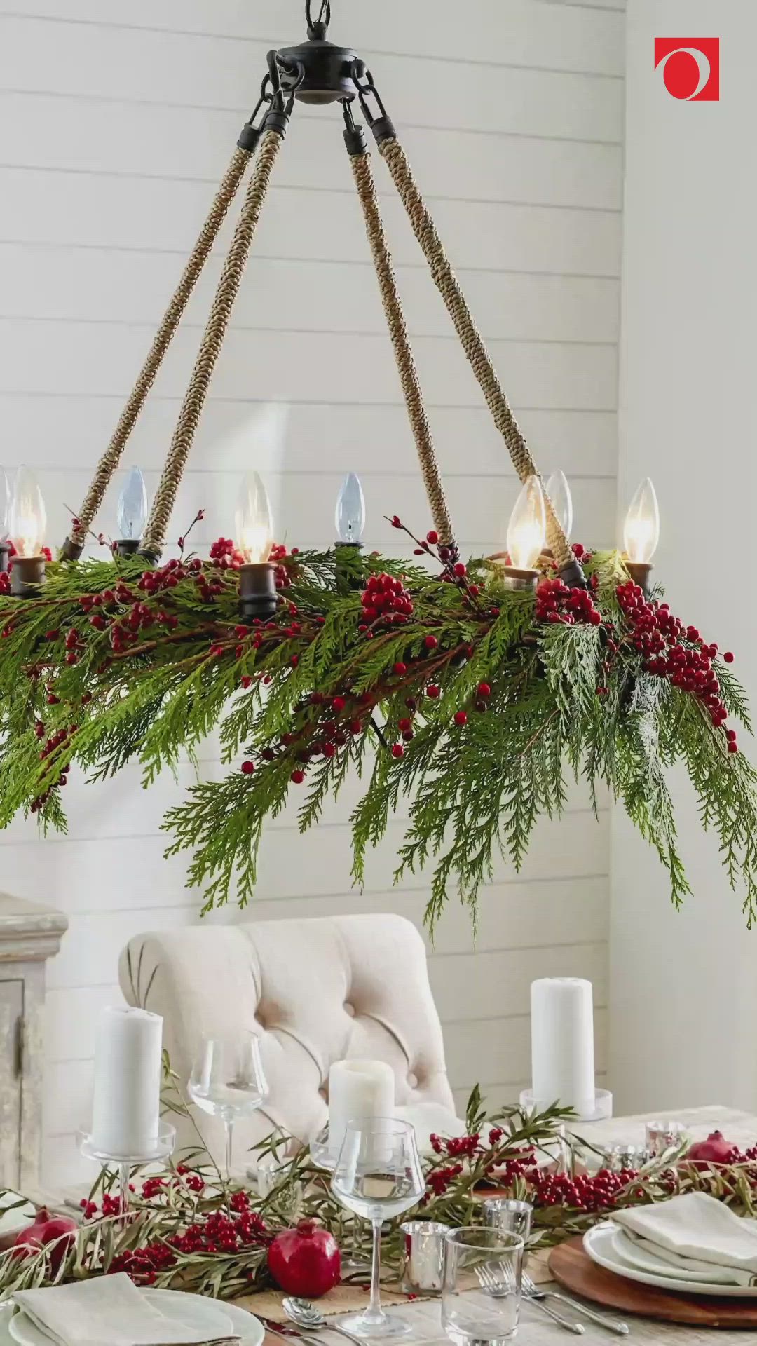 This may contain: a chandelier with candles and greenery hanging from it's centerpiece