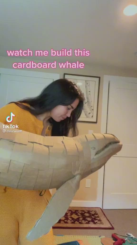 This may contain: someone is holding up a paper mache that looks like a whale