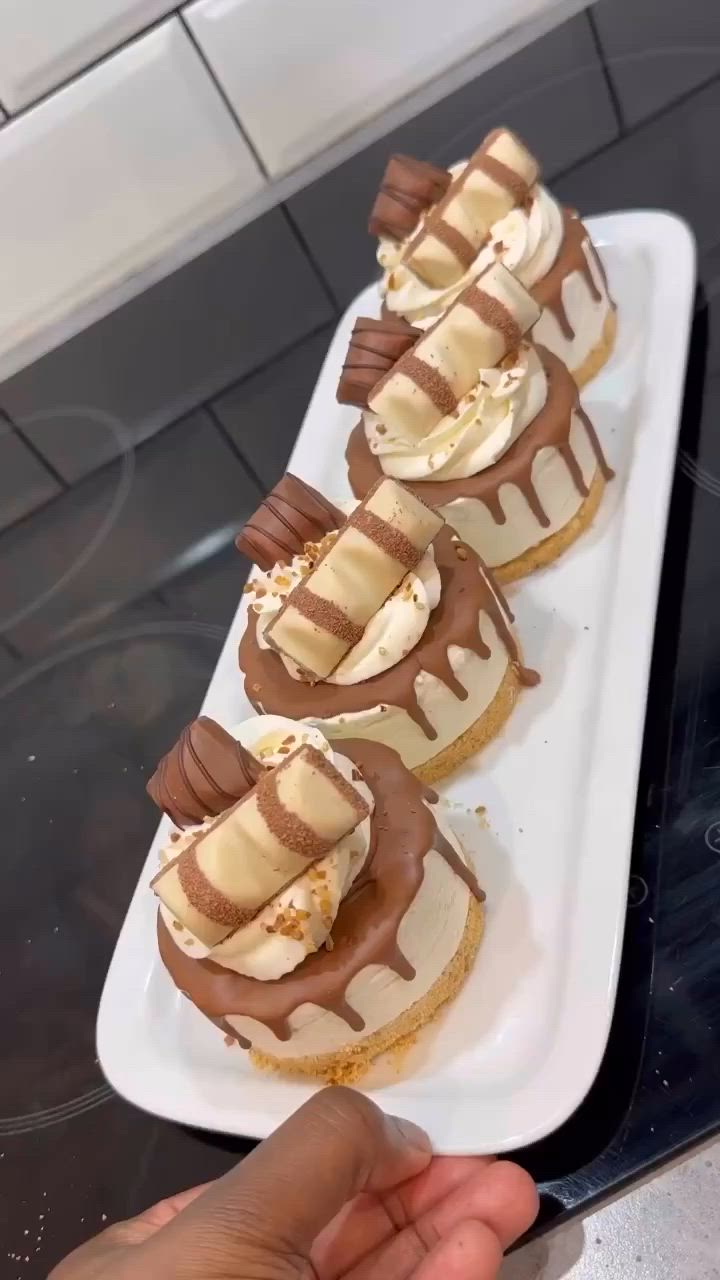 This may contain: four desserts are arranged on a white plate with chocolate drizzle and banana slices