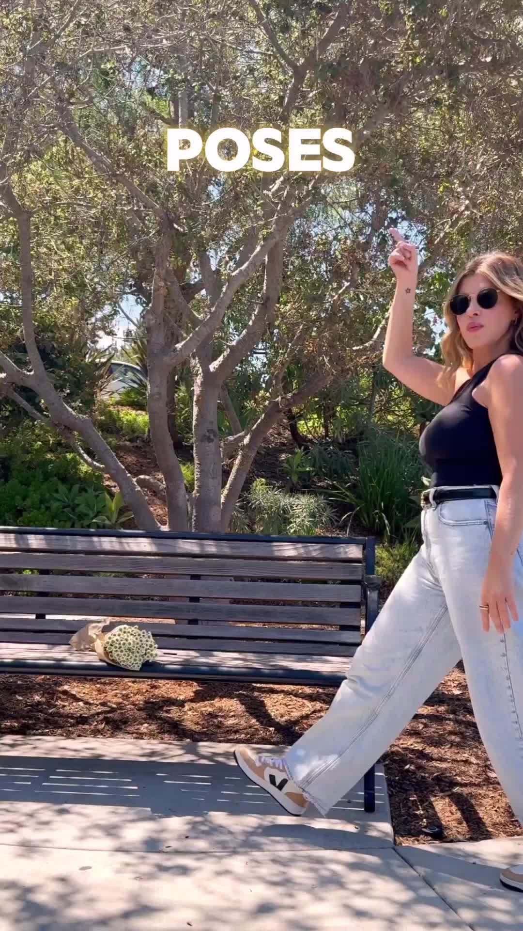 This may contain: a woman standing in front of a bench with her arms up and the words poses at the park above her