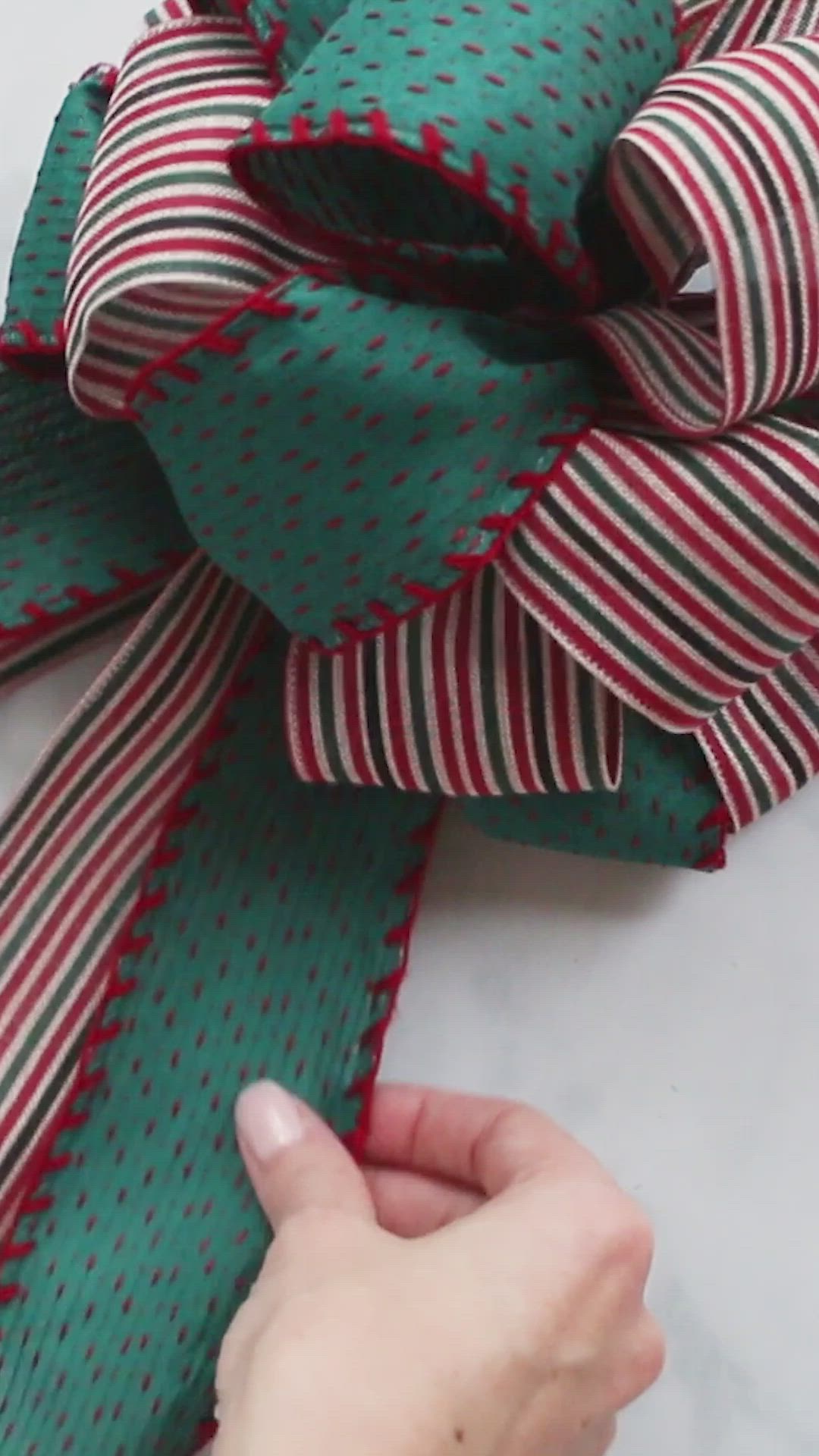 This may contain: how to make a christmas tree topper bow with red and green stripes on it