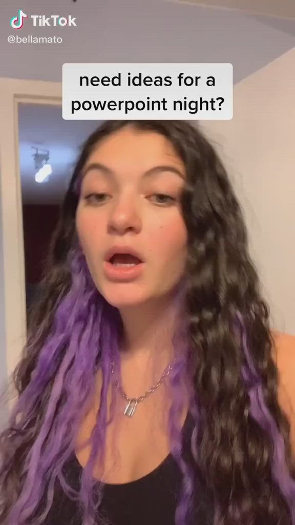 This may contain: a woman with long purple hair is talking to someone