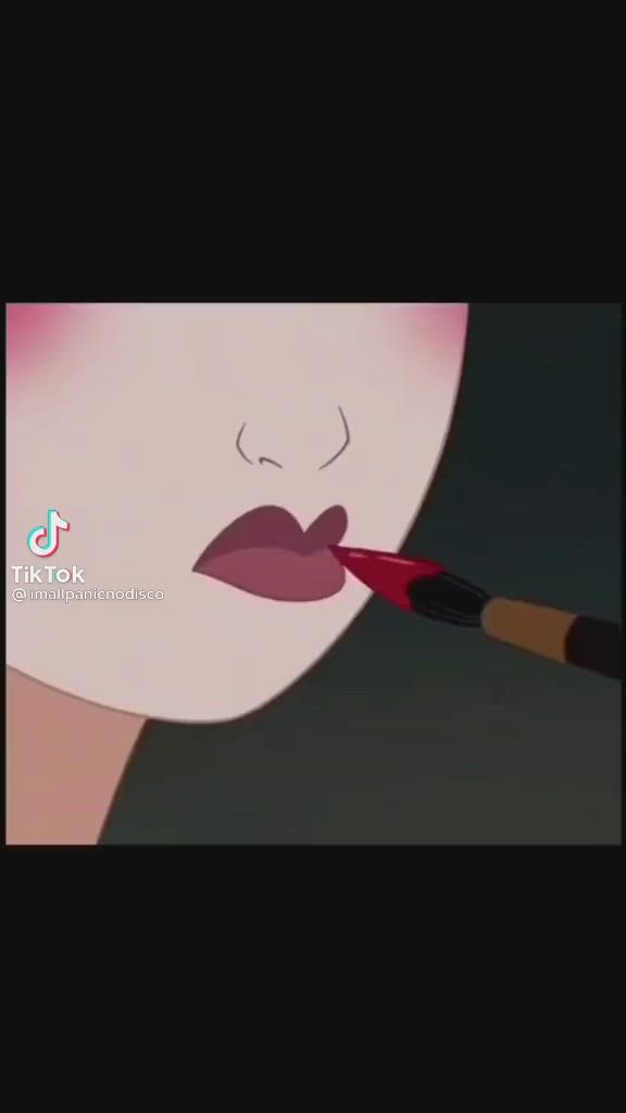 This may contain: a woman with red lipstick brushes her lips