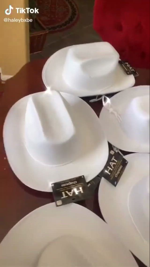 This may contain: several white hats are sitting on a table