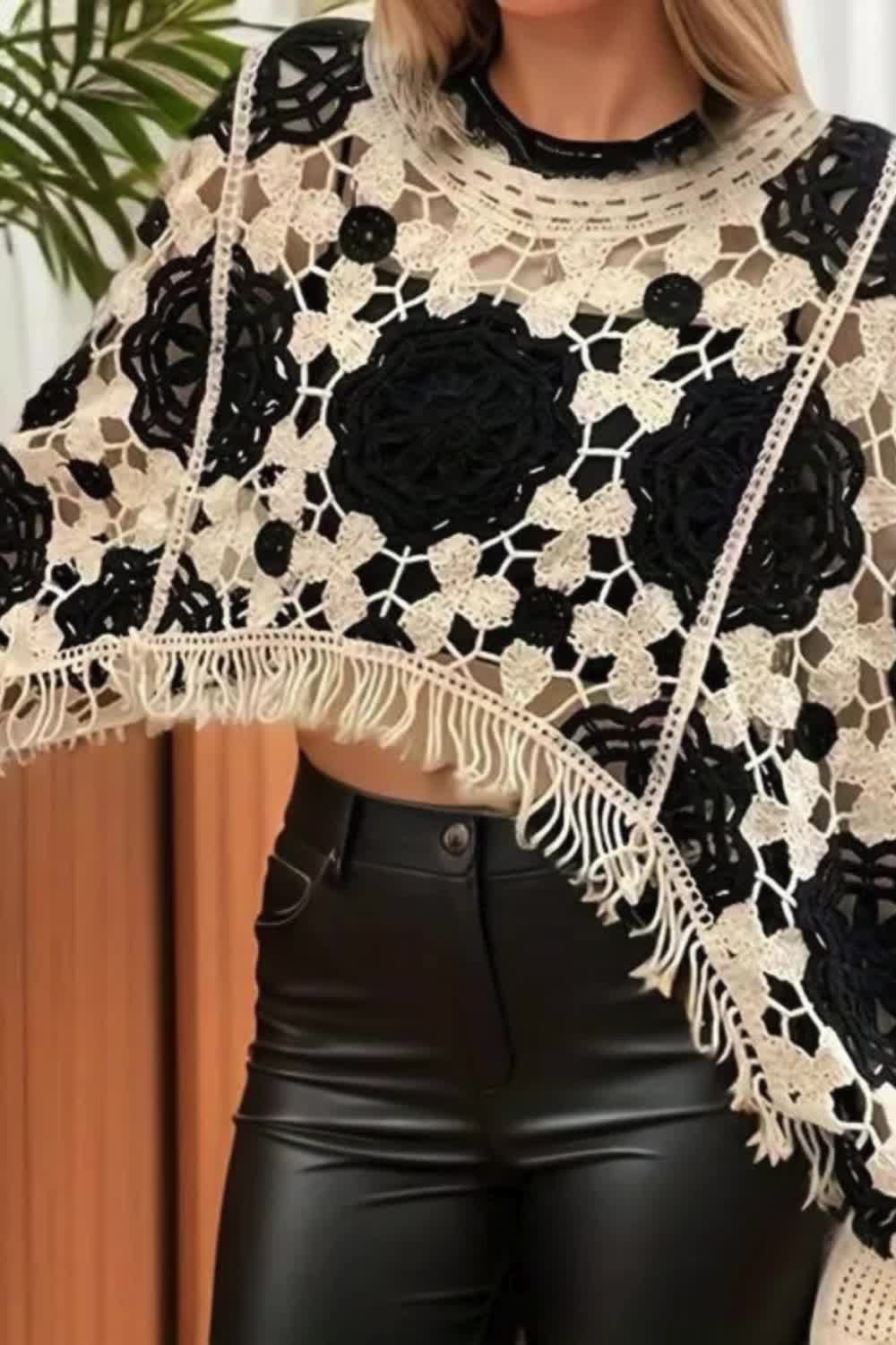 This may contain: a woman wearing black leather pants and a white lace top with flowers on the shoulders