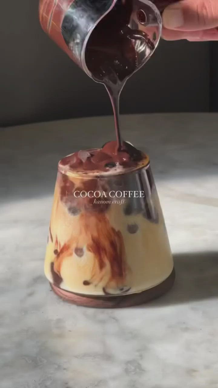 This may contain: someone is pouring chocolate into a small cup