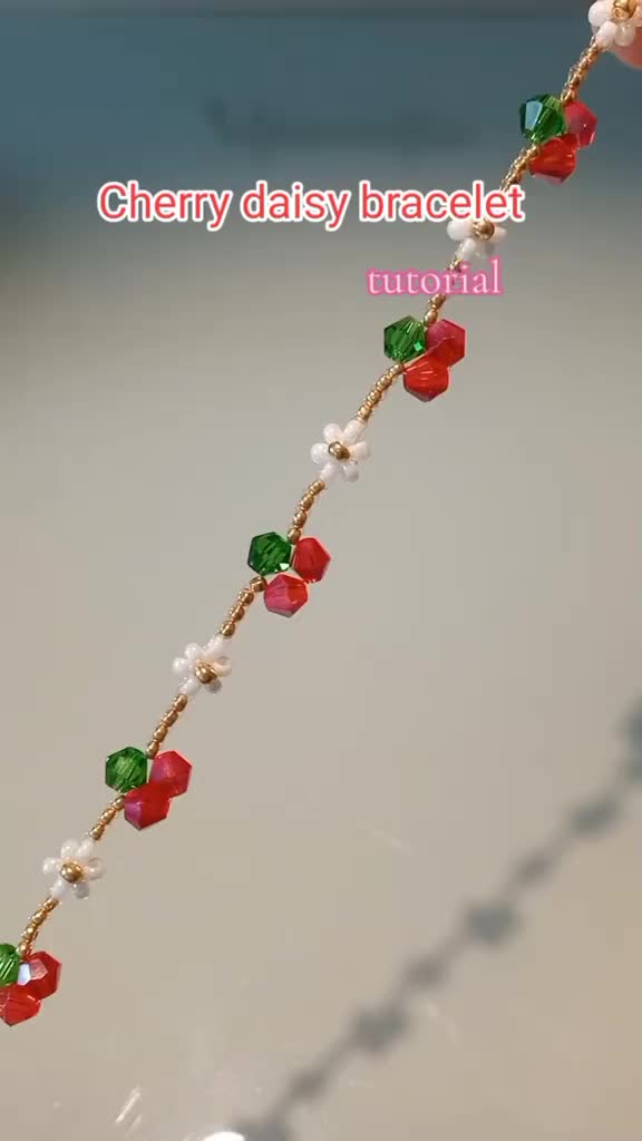 This may contain: a close up of a necklace with beads and flowers on it's chain,