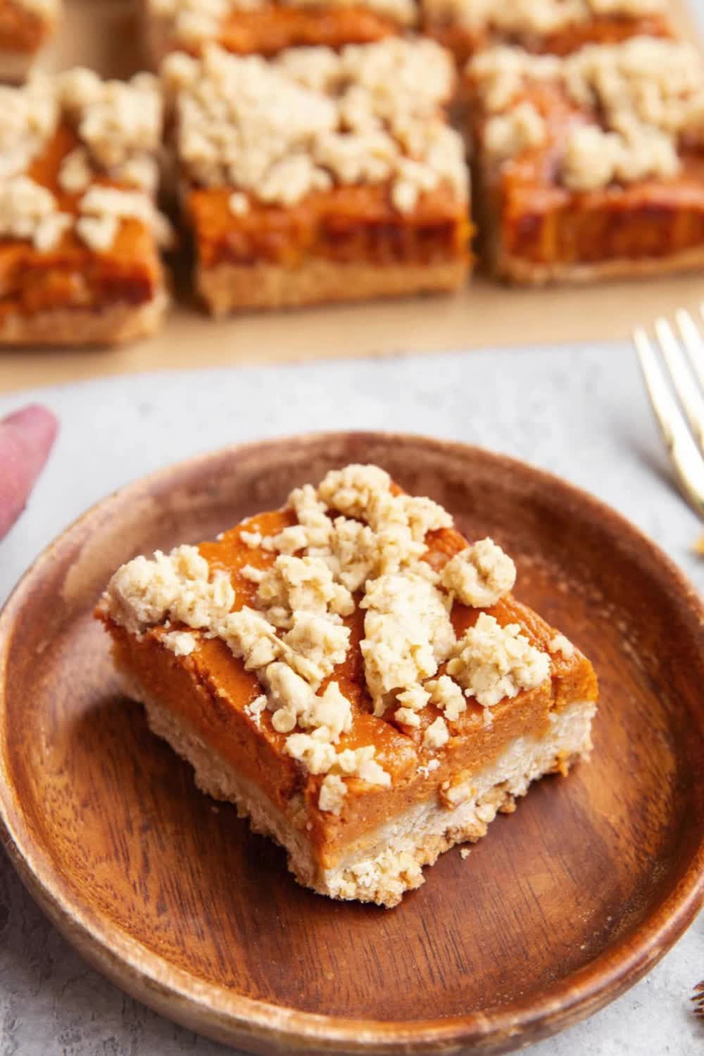 This may contain: sweet potato crumb bars on a wooden plate