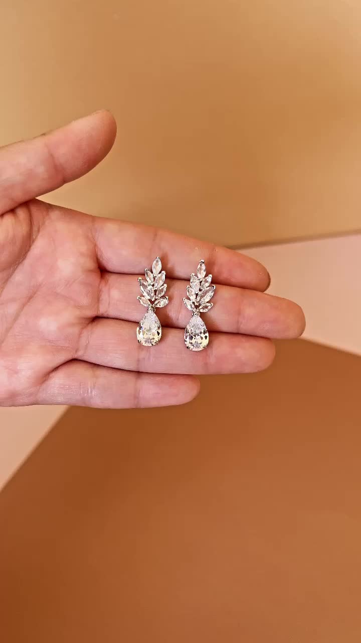 Our Gorgeous LIV Drop Earrings with Stunning Simulated Diamonds in a delicate leaf like arrangement. LIV Earrings can be styled with most of our wedding headpieces and bridal tiaras and crowns. Handcrafted with Highest Quality CZ Platinum plated - Guards against scratches and tarnish. Approx. Length 1" Approx. Length 0.5" Nickel free