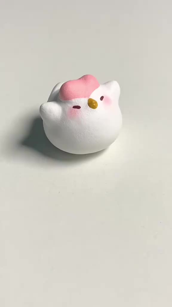 This may contain: a small white hello kitty toy sitting on top of a table