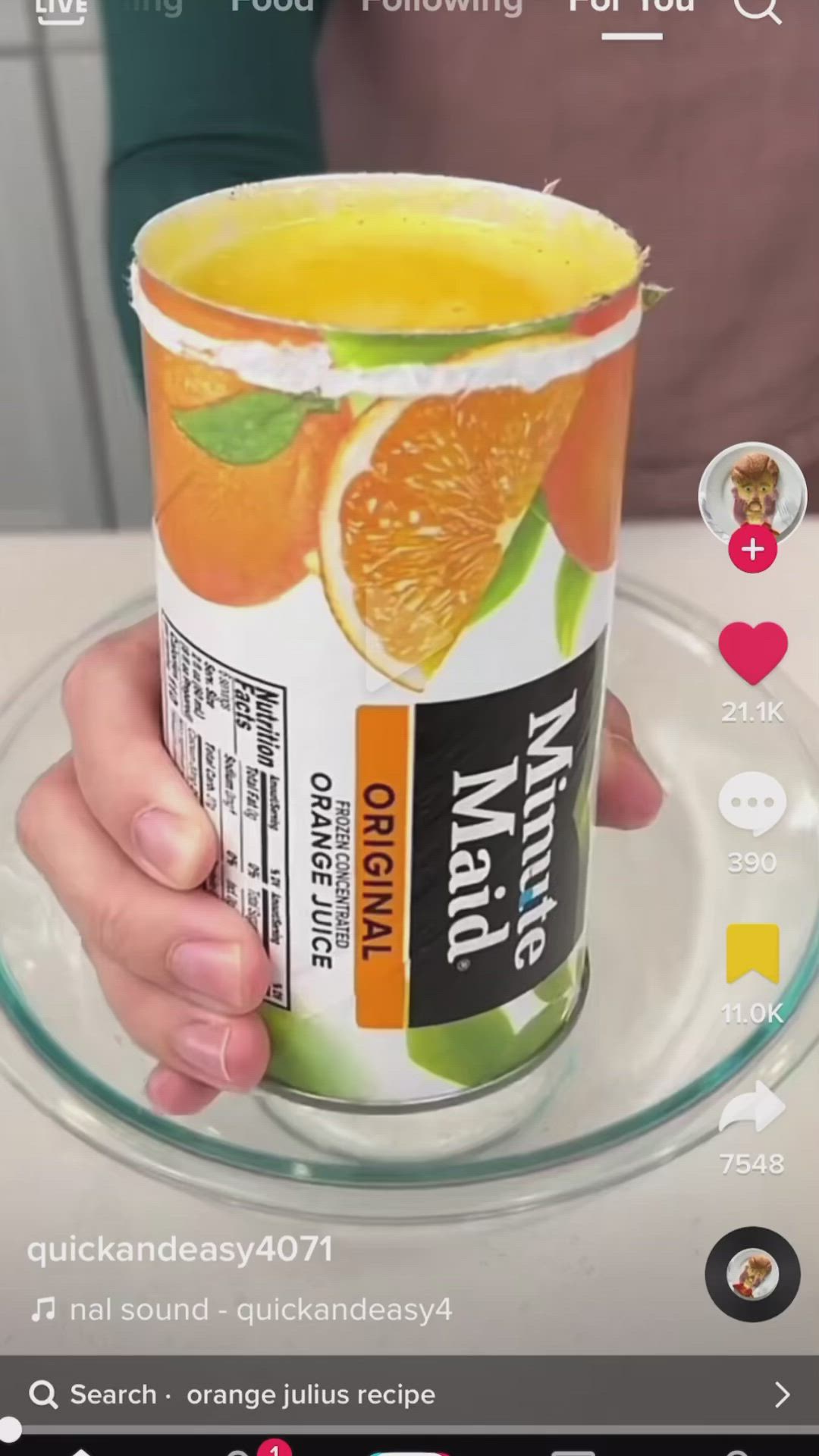 This may contain: a person holding up a cup of orange juice on a glass plate with an instagram button