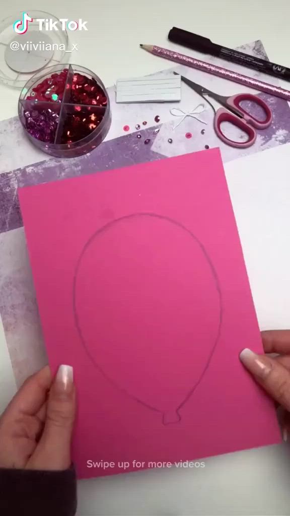 This may contain: someone is making a heart shaped card out of paper and crafting it with scissors