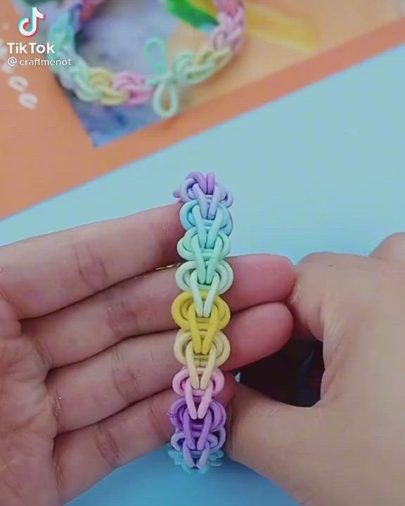 This may contain: someone is making a rainbow loom bracelet on their hand and it looks like they're doing something right now