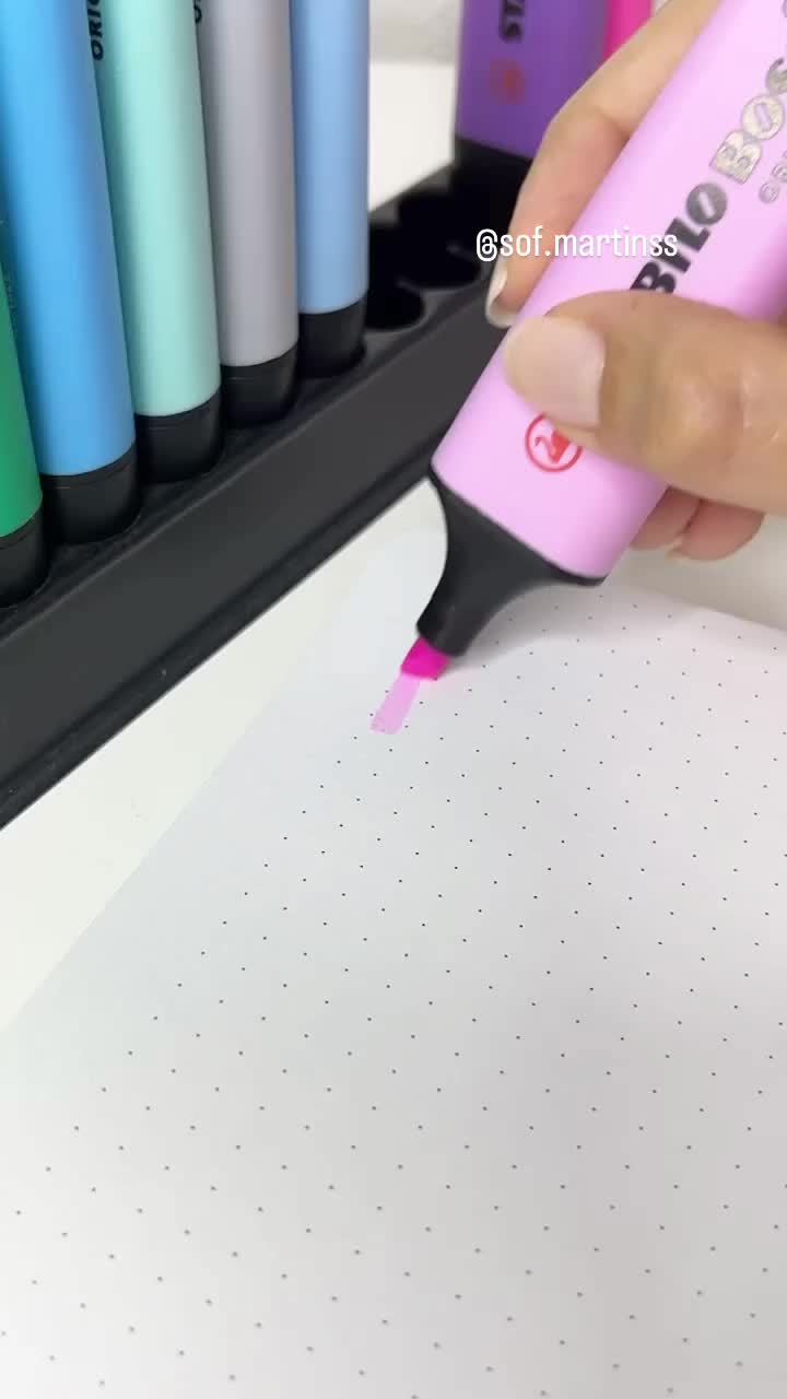 This may contain: someone is using a marker to draw flowers on a piece of paper with pink and purple ink