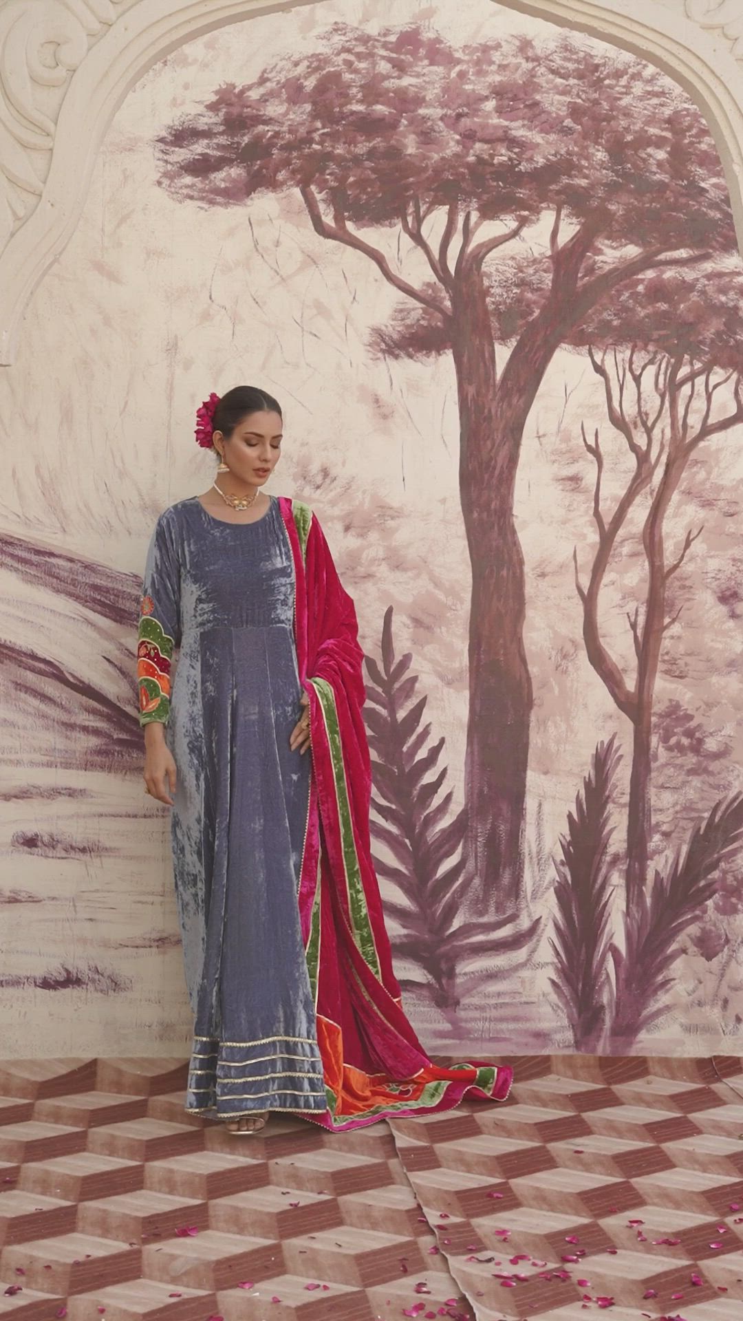 A traditional paneled steel blue pishwas, multicolored organza sleeves, with resham floral motifs and sequins, finished with gota laces at the hem. A multicolored velvet shawl dupatta paneled with gota laces and a handcrafted velvet appliqué florals at the pallu.