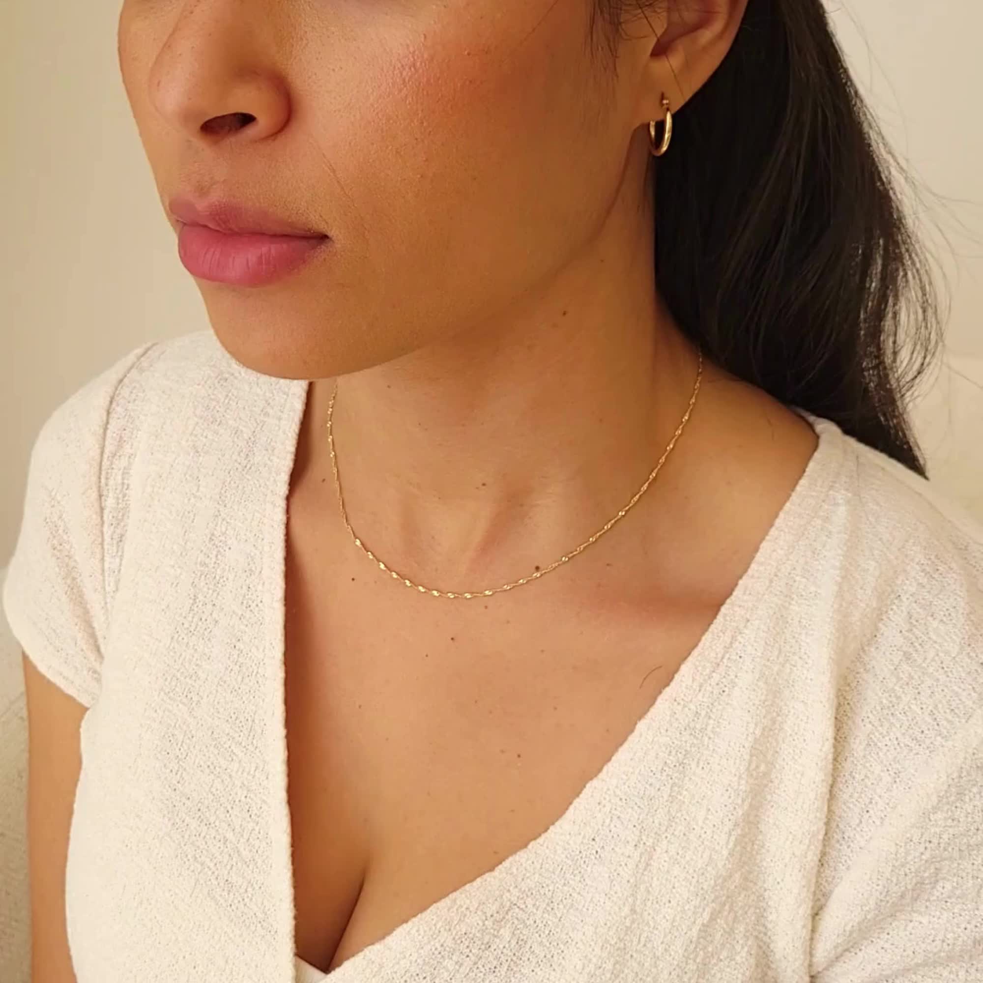 Every jewelry collection needs a sparkly chain necklace you can wear by itself or layer with others. The Singapore Chain Necklace has to be one of our favorites! Crafted in 14k solid gold, it fits every single occasion and will make you feel extra elegant and confident when it's on. Plus, it'll last many lifetimes and you can even pass it down as a heirloom necklace. You can leave it on and shower with it without worry. This dainty chain necklace is sure to be your favorite go-to for years to co