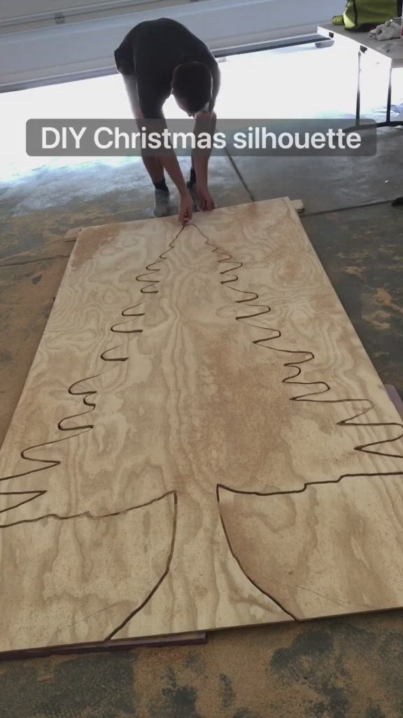 This may contain: a man is making a christmas tree out of plywood