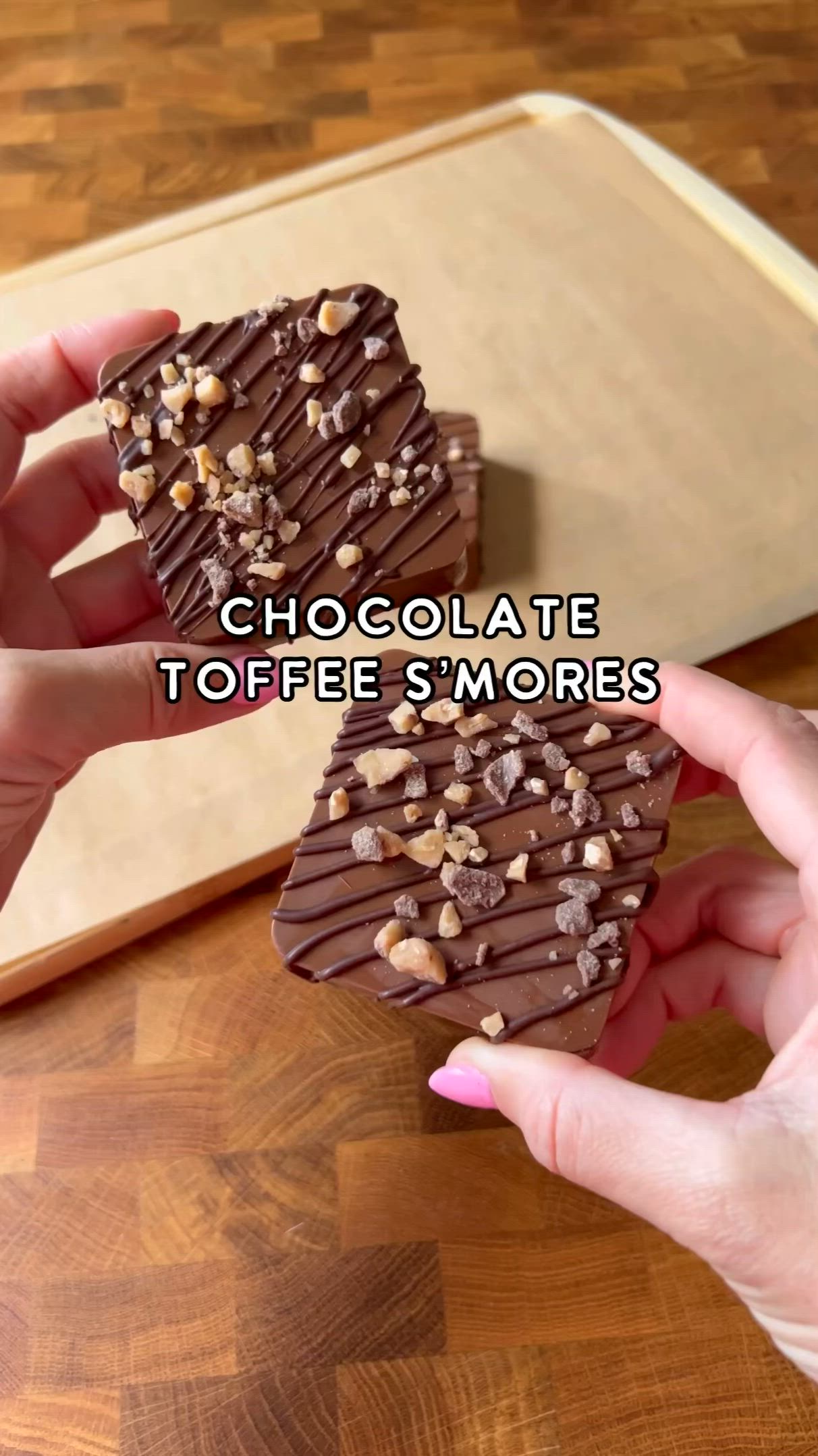 This may contain: chocolate toffee morres are being held by two hands