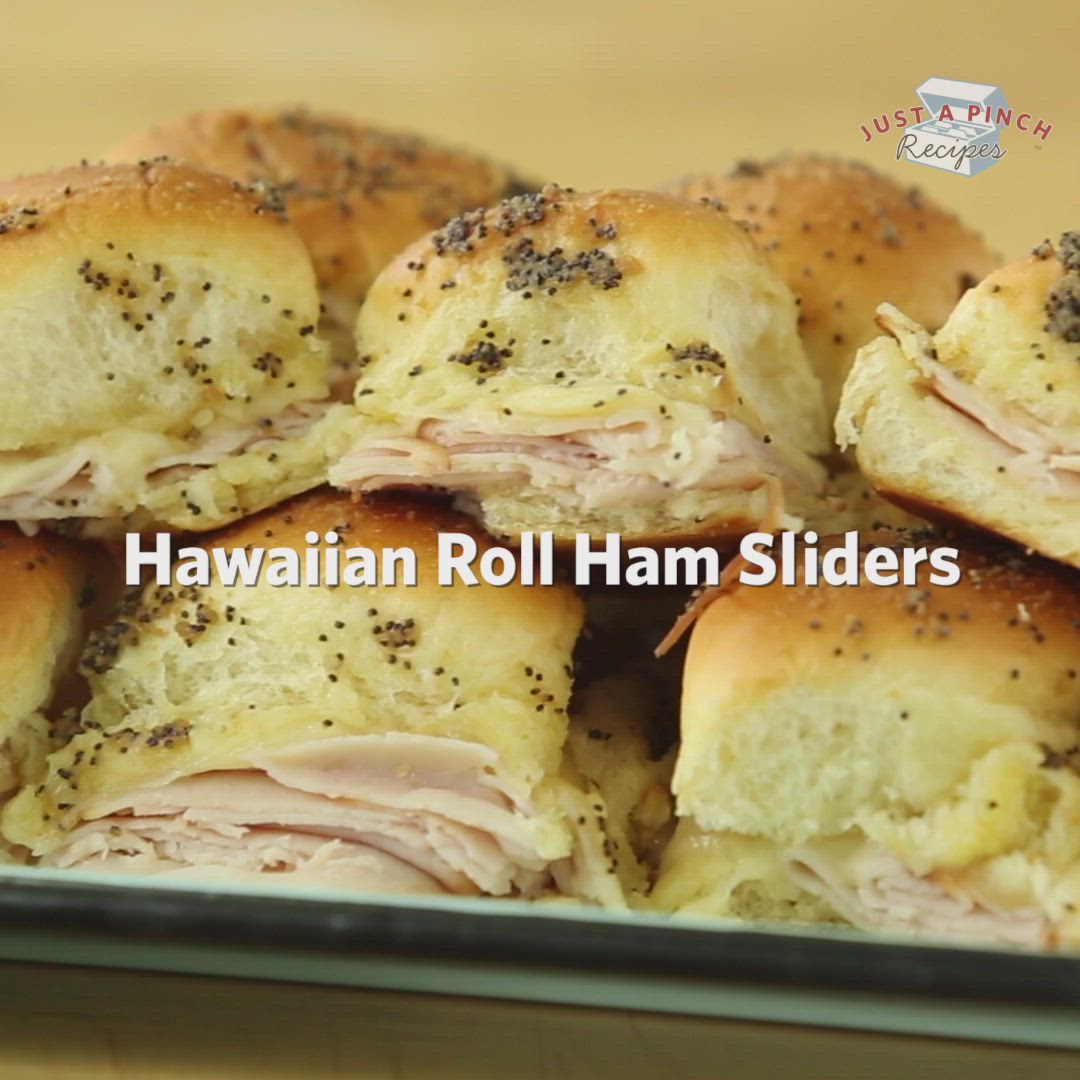 This may contain: hawaiian roll ham sliders are piled on top of each other in a baking pan