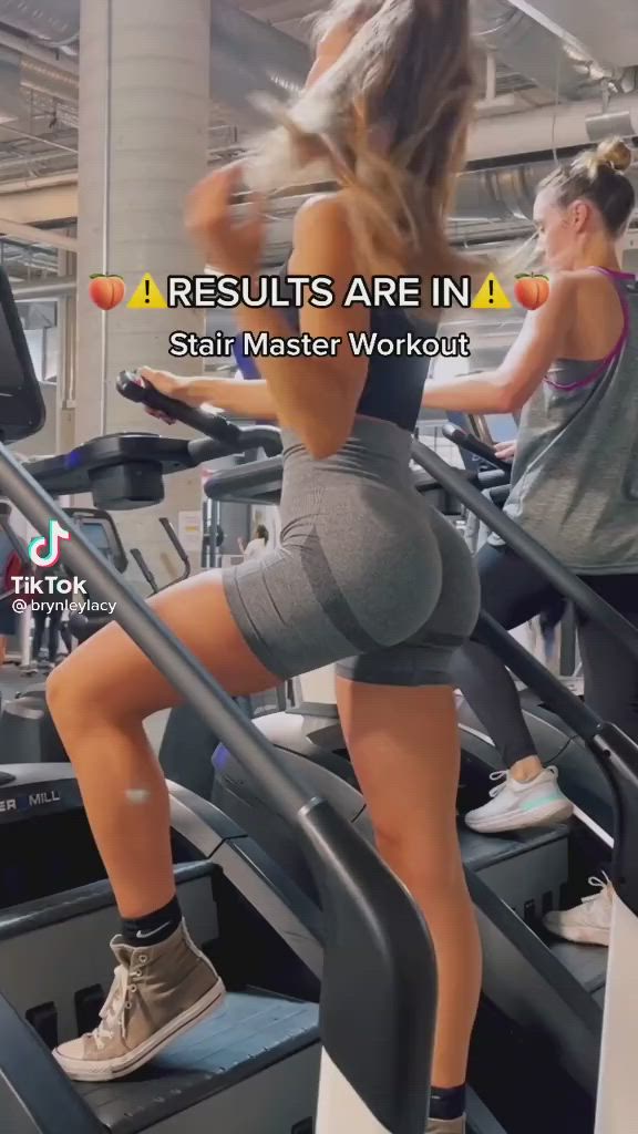 This may contain: a woman is running on a treadmill while another person works out in the background