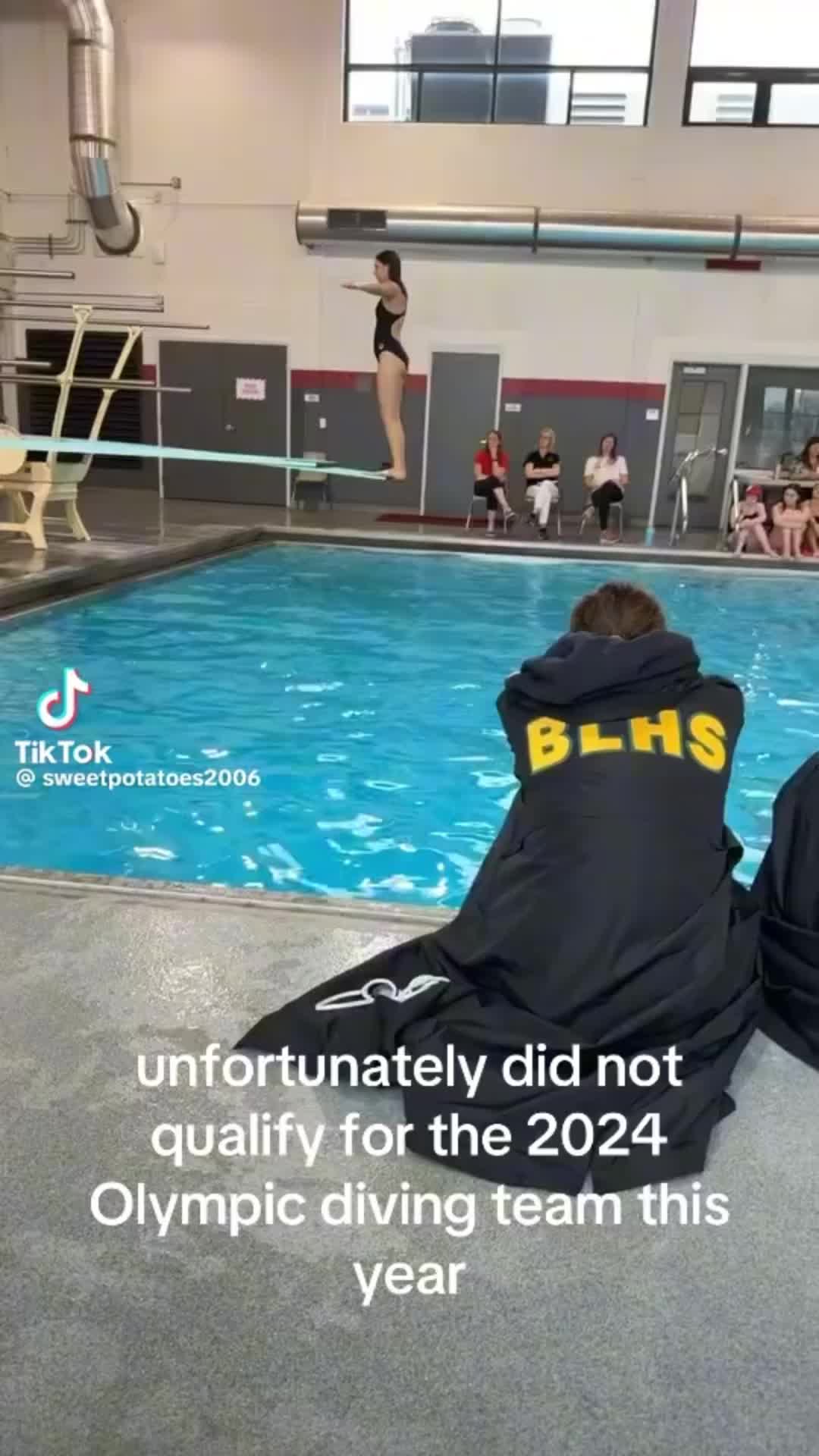 This may contain: two people sitting on the ground in front of a swimming pool with an advertisement that reads, unfortunately did not quality for the 2020 olympic diving team this year