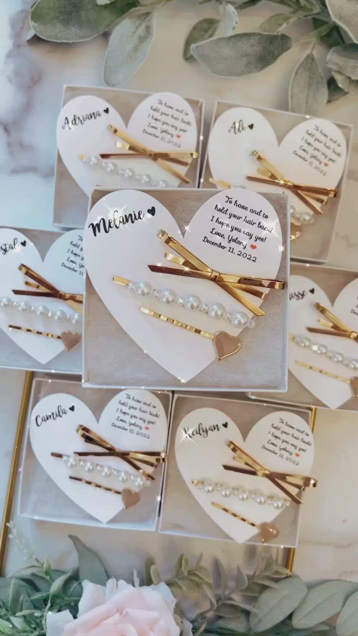 This may contain: wedding hair pins with names and pearls on them