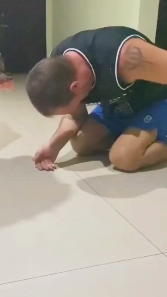 This may contain: a man playing with a kitten on the floor