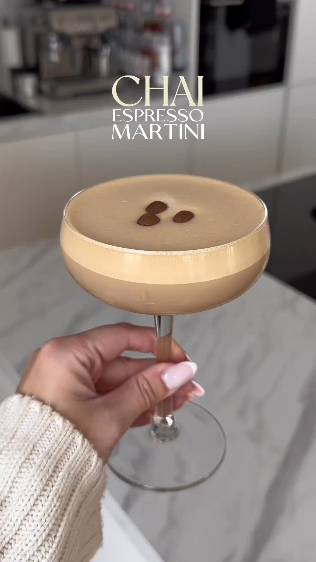 This may contain: a person holding a wine glass with a drink in it and the words chai expresso martini