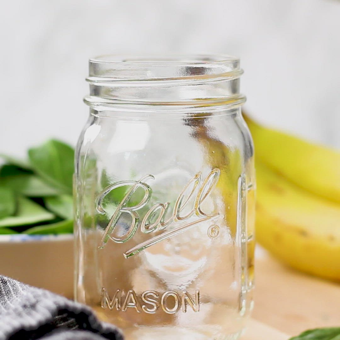 This may contain: a green smoothie is in a mason jar