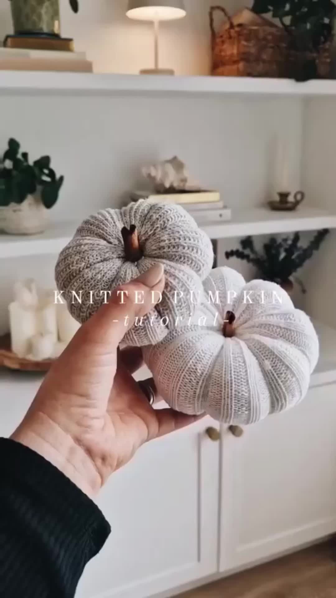 This may contain: a person is holding three yarn pumpkins in their hand