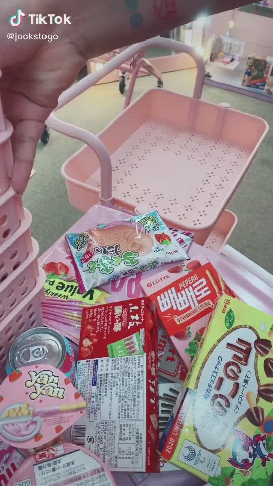 This may contain: a pink cart filled with lots of food and drinks on top of a carpeted floor