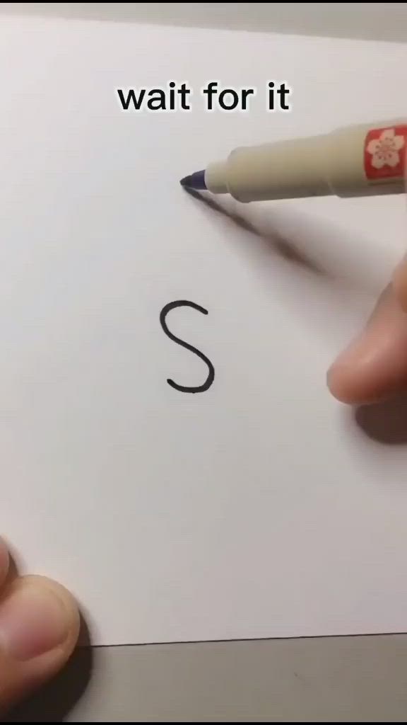 This may contain: someone is writing the letter s with a marker