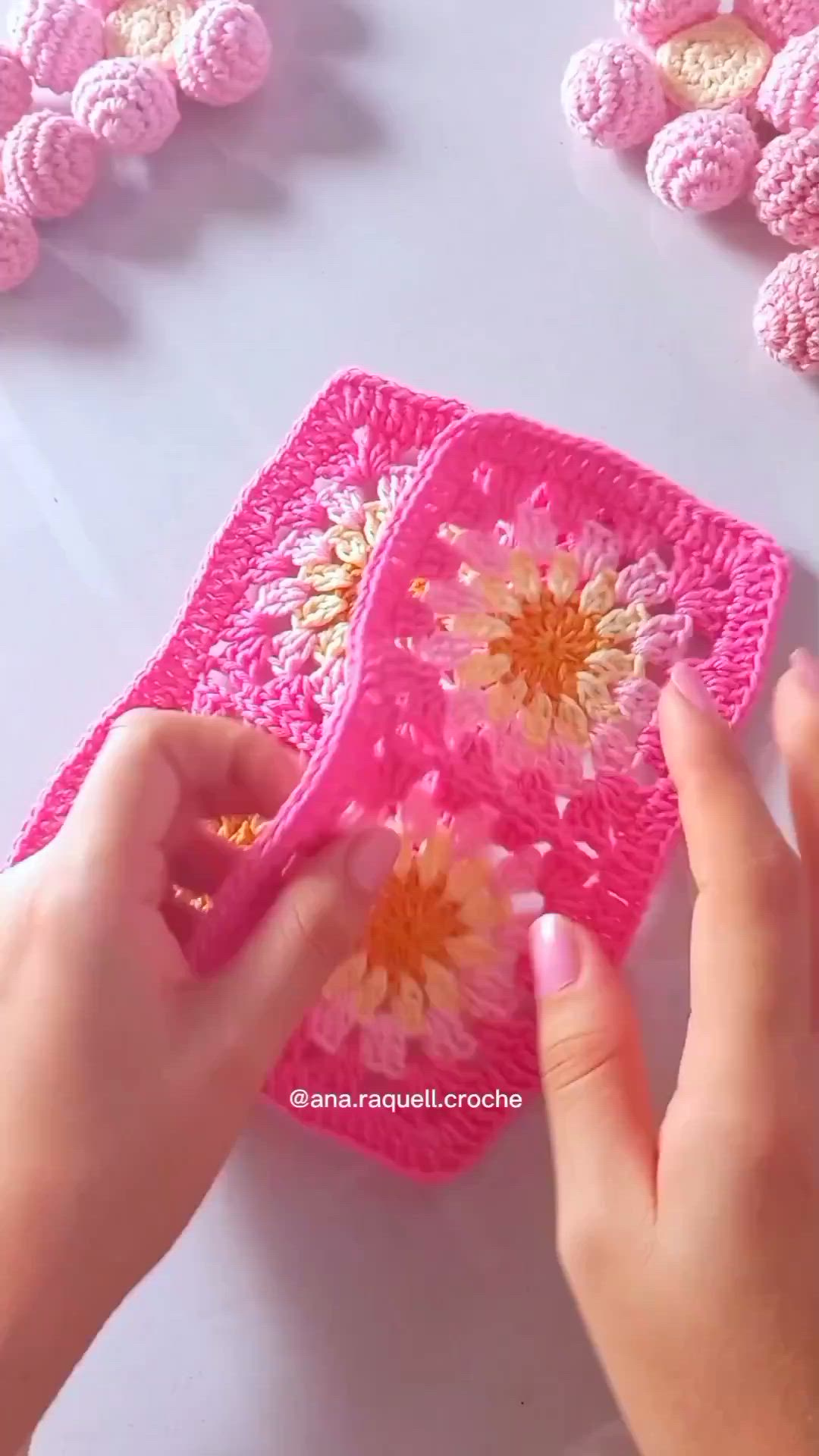 This may contain: someone is crocheting flowers on a pink doily