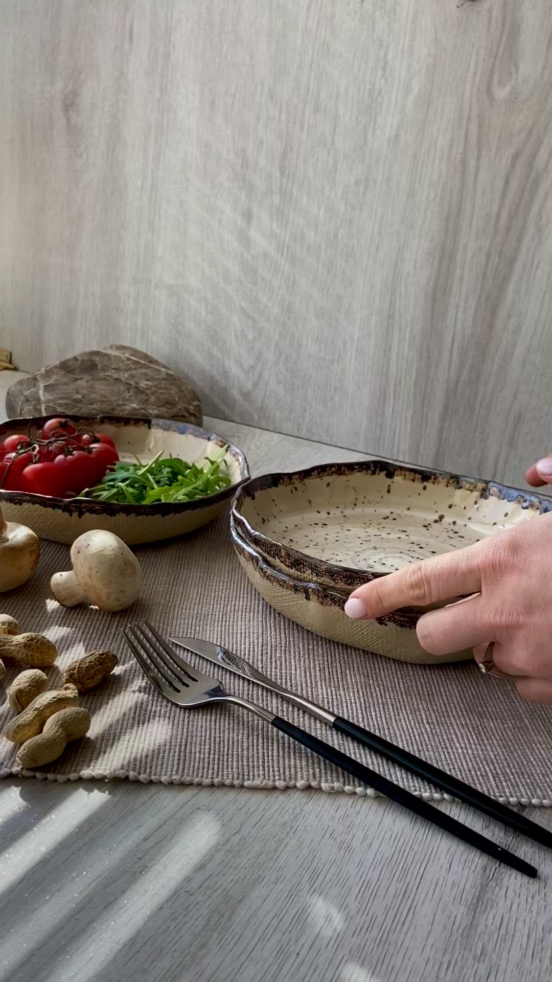 This may contain: a person holding two plates with food on them next to other dishes and utensils