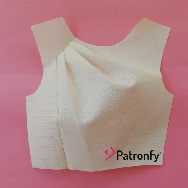 This may contain: the back of a white top with an open neckline on a pink background that says patronfy