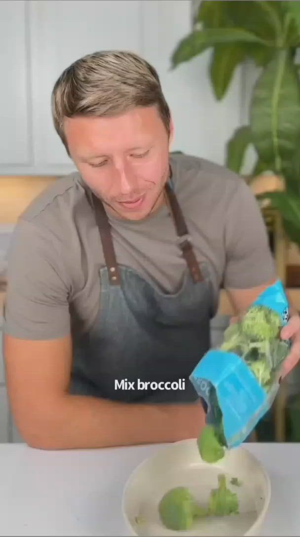 This may contain: a man in an apron pours broccoli into a bowl