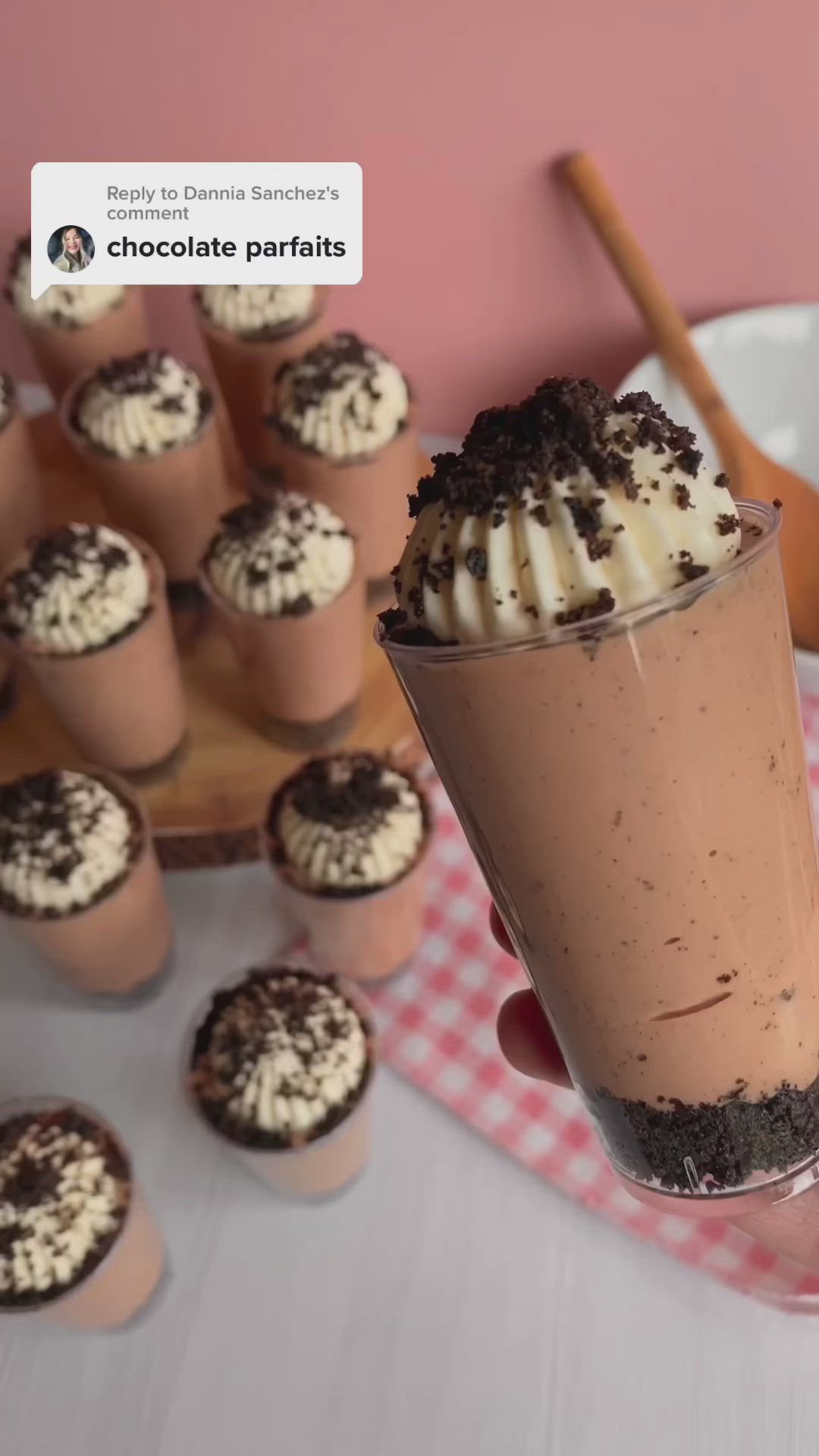 This may contain: a person holding up a cupcake with whipped cream and chocolate sprinkles