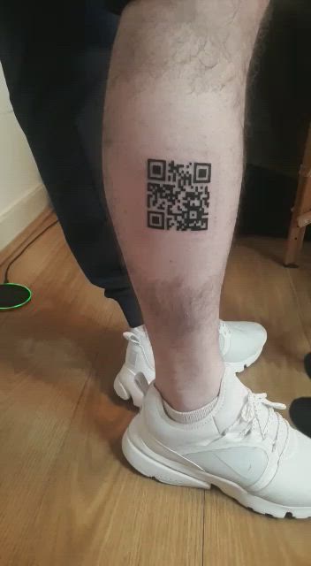 This may contain: a man with a qr code tattoo on his leg