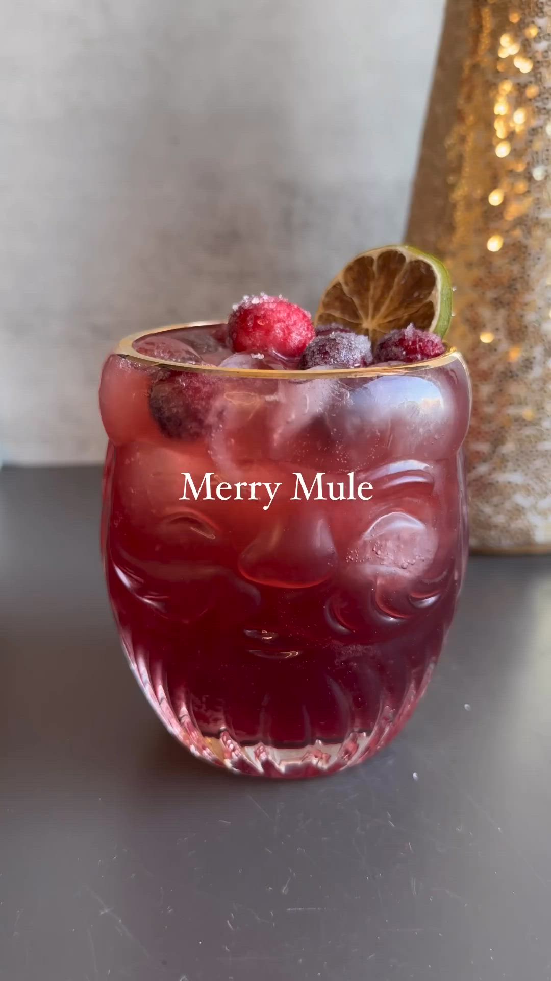 This may contain: a person holding a glass with some fruit in it and the words merry mulle above it