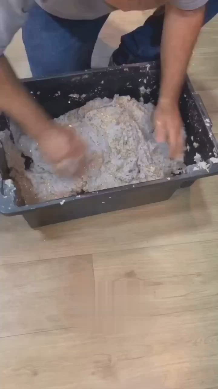 This may contain: a man is kneading dough in a pan on the floor with his hands