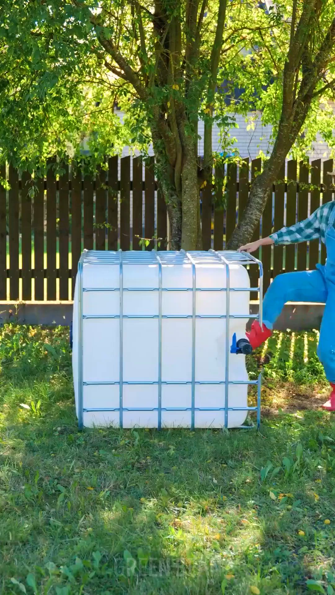 This may contain: a man in blue pants and red boots is leaning on a white box outside near a tree