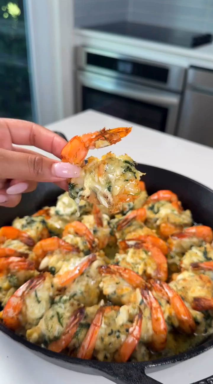 This may contain: a person is dipping some food into a skillet with shrimp and spinach on it