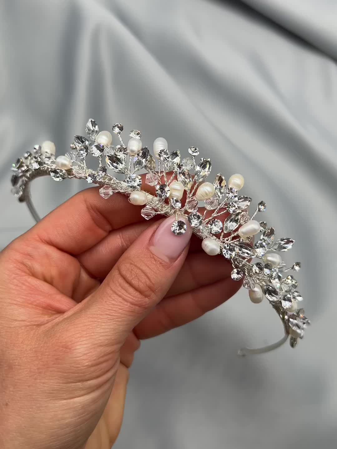 A stunning blend of classic elegance and modern design, our Aspen Pearl & Crystal Tiara adds an effortless touch of sophistication to your bridal look. Hand-wired with freshwater pearls and crystal gemstones, this tiara offers a delicate sparkle while remaining lightweight and comfortable to wear. Design: Crafted with freshwater pearls and crystal gemstones for a timeless, radiant look. Dimensions: Measures 1 inch at the center peak—ideal for adding just the right amount of height and drama. Fit