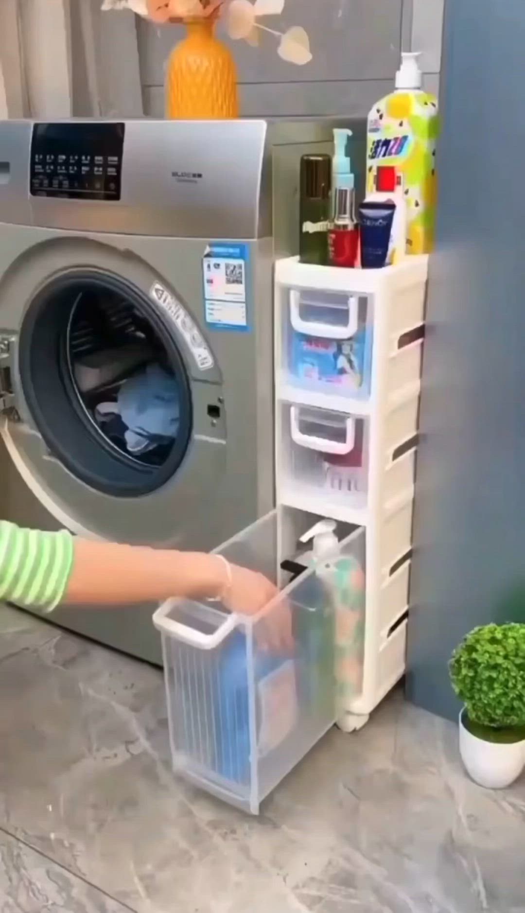 This may contain: a little boy that is standing in front of a washing machine