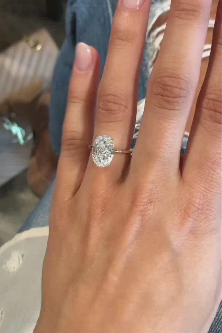 This may contain: a close up of a person's hand with a diamond ring on their finger