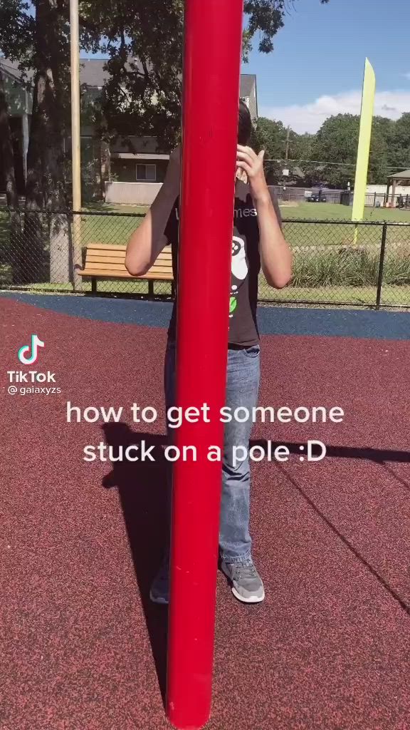 This may contain: a person standing next to a red pole