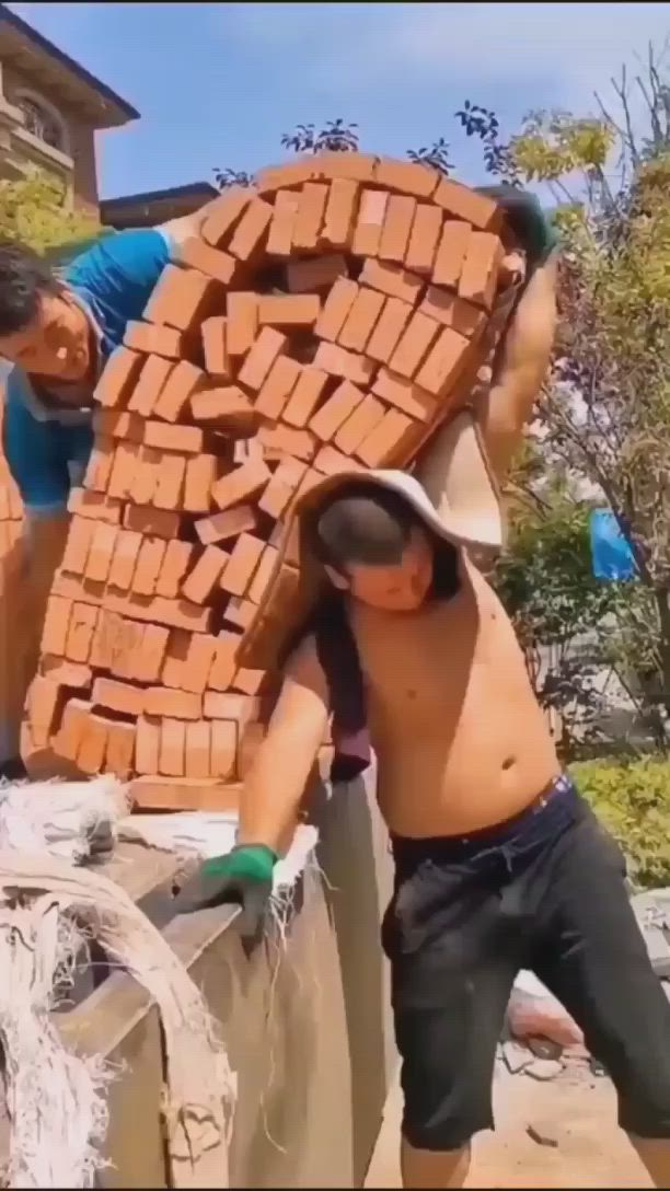 This may contain: two men are building bricks on top of each other