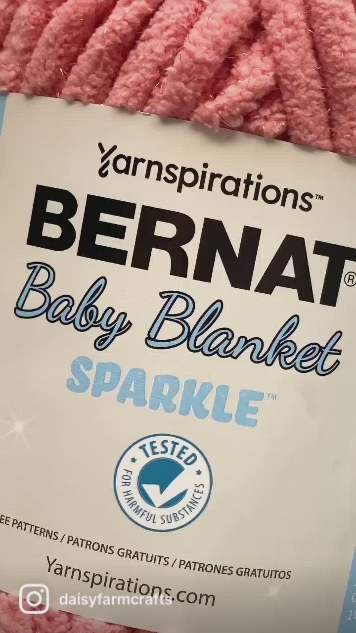 This may contain: the yarn is pink and has a label on it that says bernat baby blanket sparkle