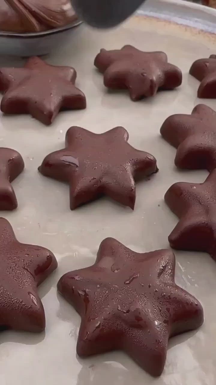 This may contain: a red star shaped cake pan being filled with water and chocolate chips in the background