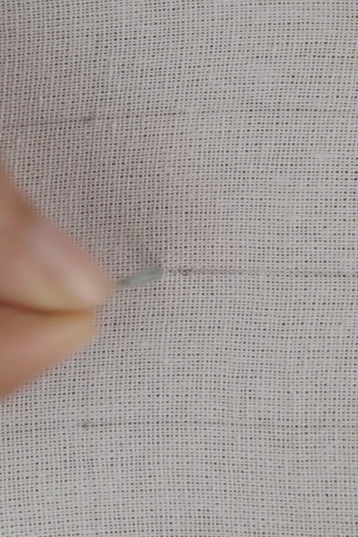 This may contain: someone is working on some thread with their fingers and thumbnails in order to finish the stitch